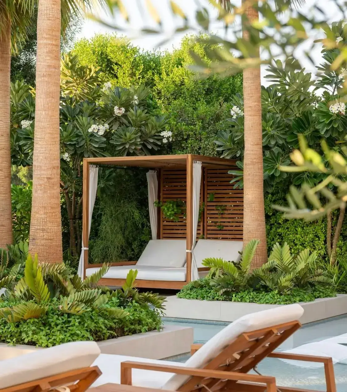 Luxury garden cabana surrounded by tropical greenery and palm trees in a modern Dubai villa landscape. Designed by Reshape Landscaping and Design, a British-owned company in Dubai creating bespoke outdoor living areas and premium landscape architecture.