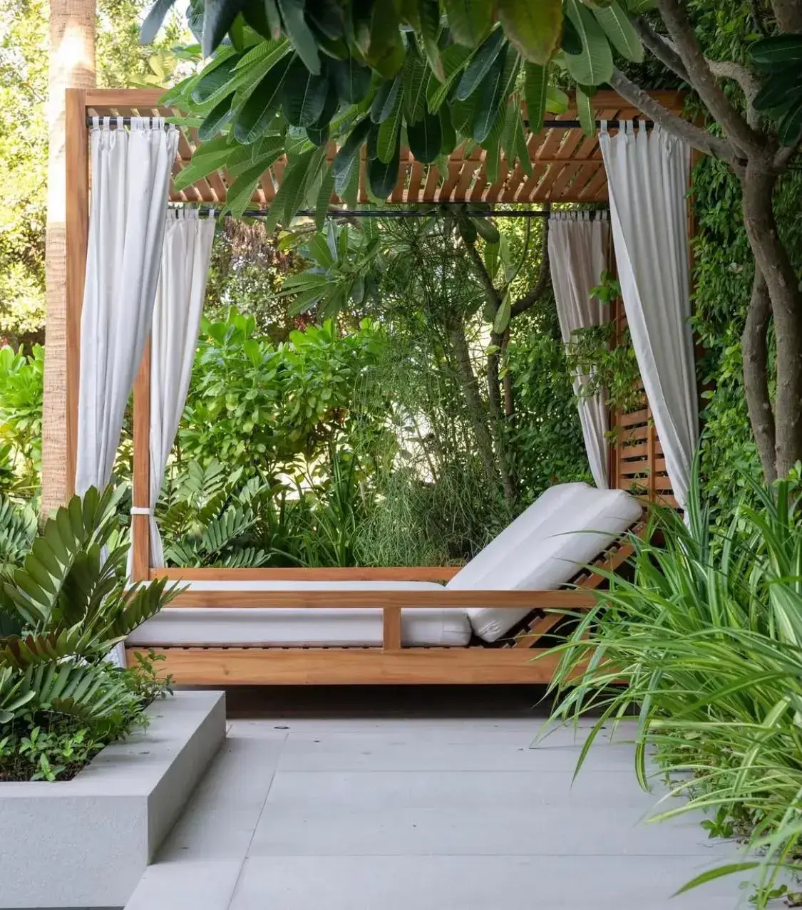 Modern wooden cabana surrounded by tropical greenery in a Dubai villa garden. Designed by Reshape Landscaping and Design, a British-owned landscaping company in Dubai specialising in luxury outdoor living, shaded seating areas, and contemporary garden design.