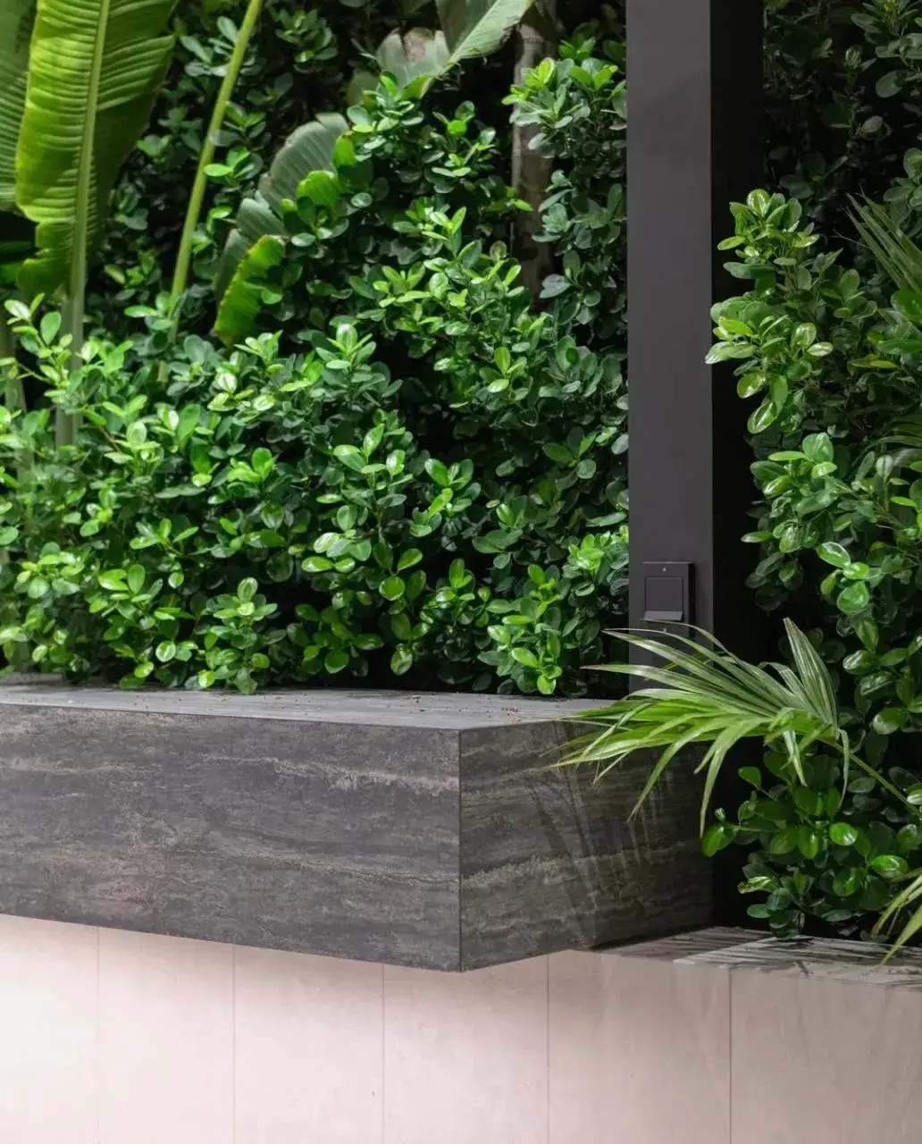 Contemporary stone planter with tropical greenery in a modern Dubai villa garden. Designed by Reshape Landscaping and Design, a British-owned landscaping company in Dubai specialising in minimalist outdoor architecture and luxury landscape detailing.